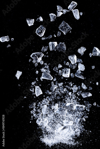 Ice cubes crushed on a black background. Flying shards of ice.
