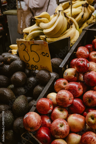 Vertical image of healthy fruit ripe avocados, red apples and bananas ready to sell and eat inside the building of the Central Market in Adelaide Australia.