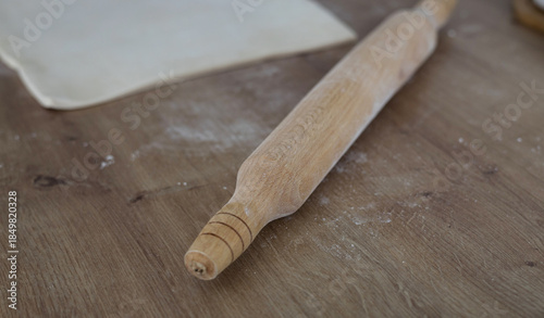 Classic wooden rolling pin with freshly prepared dough