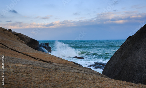 Two rocks form a huge V shape, and the emerald sea churns up velvety waves.