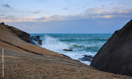 Two rocks form a huge V shape, and the emerald sea churns up velvety waves.