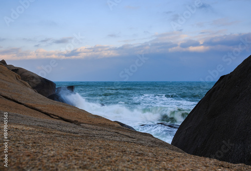 Two rocks form a huge V shape, and the emerald sea churns up velvety waves.