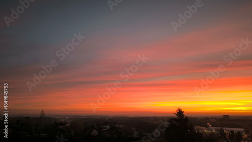 colorful sky at sunrise with aircraft trails in December above Petrovaradin