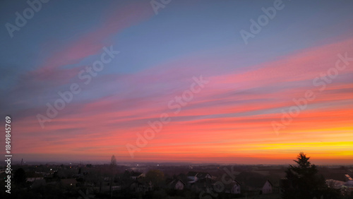 colorful sky at sunrise with aircraft trails in December above Petrovaradin