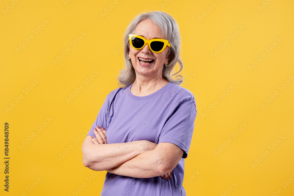 Fototapeta premium Senior woman laughing, wearing yellow sunglasses, expressing happiness and joy