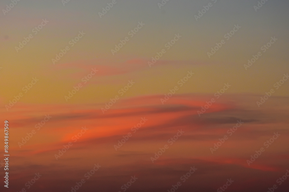 Fototapeta premium Simple sunset sky background with soft clouds and warm light
