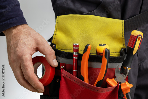 Photos Close-up of tools belt on electrician worker