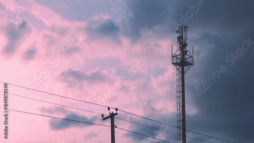 Cell Tower, Cellular GSM Tower with 3g, 5g Transmitter, Mobile Communication and time lapse of colorful rainy sunset sky in sunlight and puffy pink and black dark storm clouds 4K.