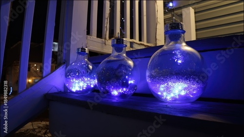 three large, light-up christmas ornaments with blue lights on the front porch