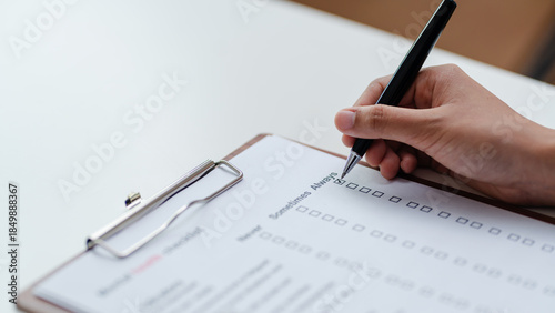 Fotografie Person filling mental health checklist on clipboard with pen, psychological assessment, self evaluation, healthcare screening and wellbeing awareness concept