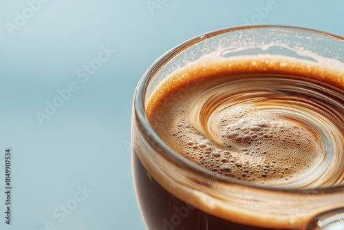 Glass of beverage with swirling texture, close up.