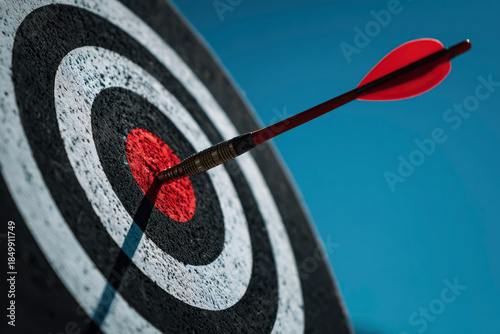 Red dart hitting the bullseye on target