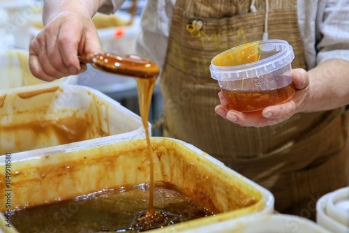 A farmer pours honey at the market