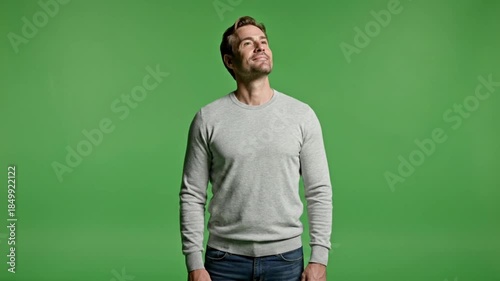 Casual Man Standing And Looking Up On Green Screen Background For Studio Video And Photo Editing