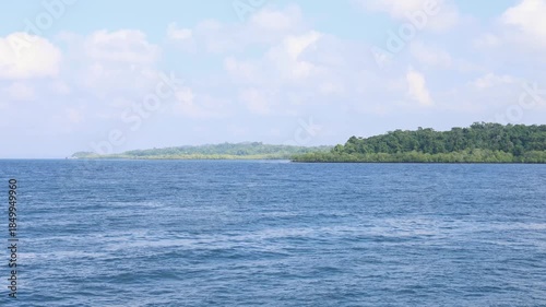 calm ocean view with distant tropical island under blue sky
