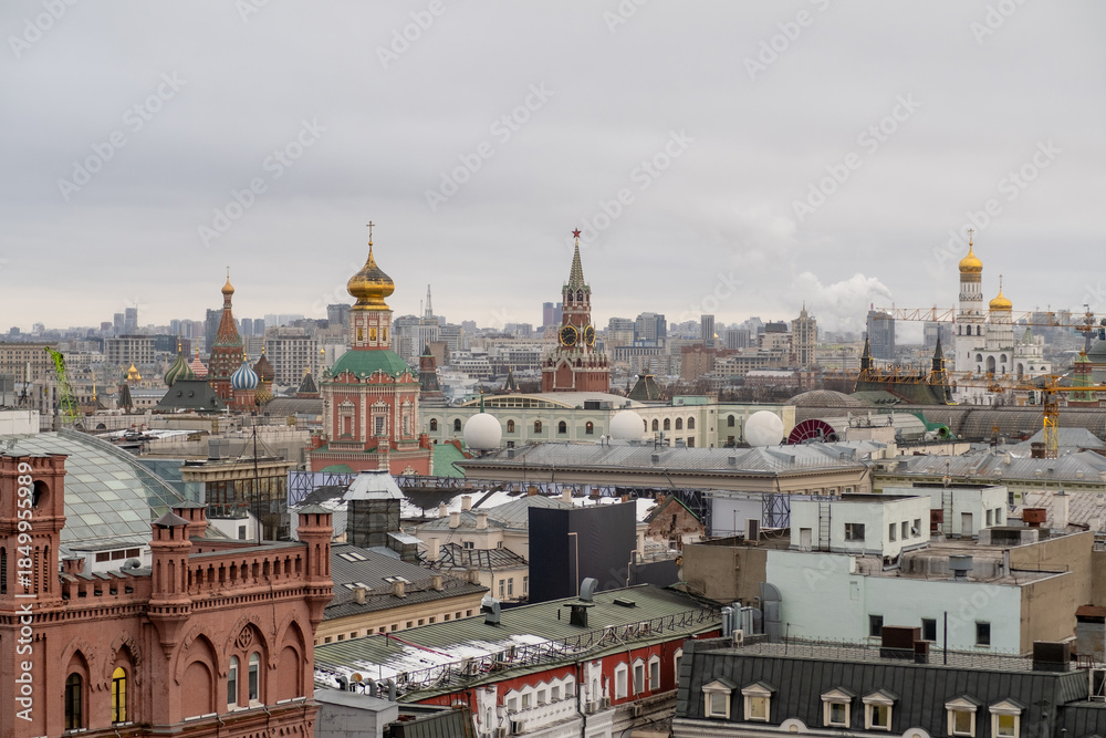 Fototapeta premium Urban Skyline View of Historic Buildings in Moscow With Colorful Domes and Modern Cityscape Under Overcast Sky