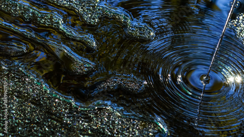 Abstract circular water waves with shimmering blue, gold and silver light reflections. Modern liquid background with ripple patterns, sparkle texture and copy space for design, desktop and branding.