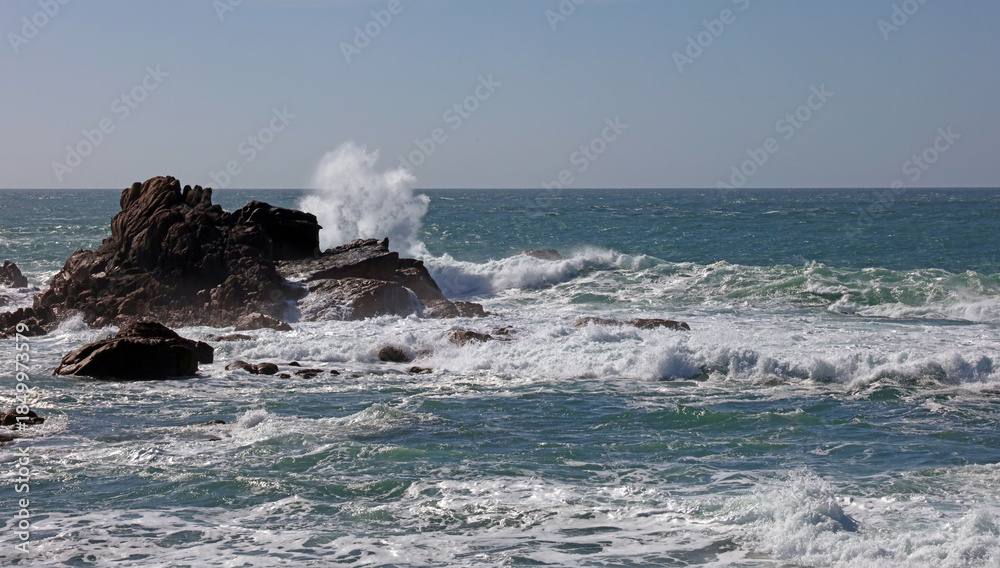 Fototapeta premium Waves breaking over granite rocks, Jersey, Channel Islands 