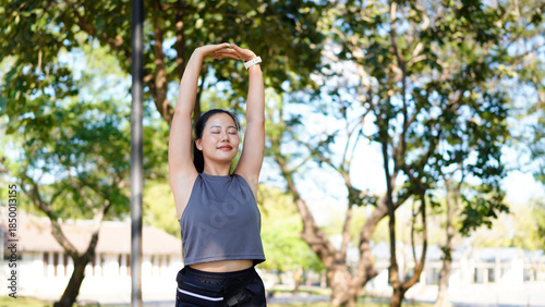Photos Healthy young Asian runner woman warm up the body stretching before exercise at park under warm light morning