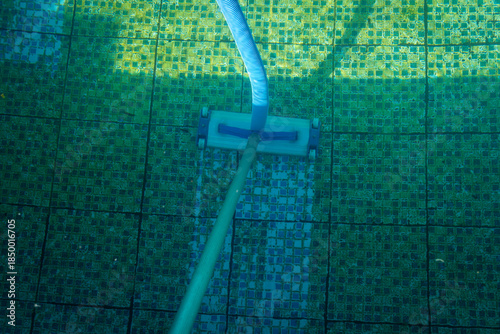 A pool cleaner at the bottom of a dirty swimming pool