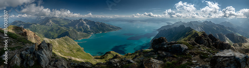 A sweeping view of mountains with a lake in the middle, overlooking the sky and clouds.