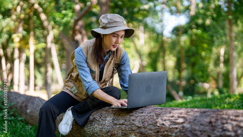Valokuva Asian adult woman biologist explorer works laptop research plant data nature stu