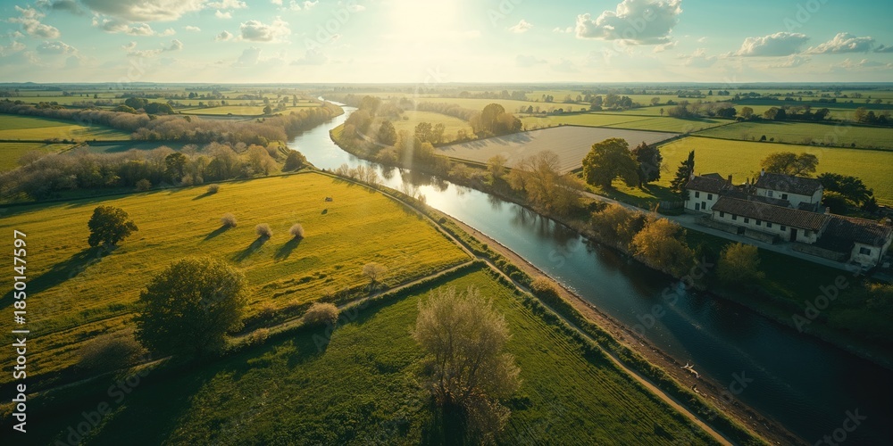 Naklejka premium Green meadows in countryside near water, captured from a drone, suitable for nature documentation