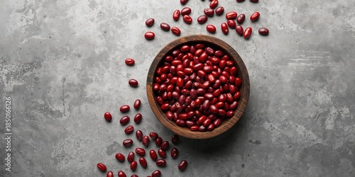 Raw kidney beans in a wooden bowl placed on a grey stone surface, highlighting food storage and handling