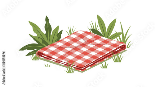 A red and white checkered picnic blanket is neatly folded on the grass surrounded by lush green plants, creating a charming outdoor scene.