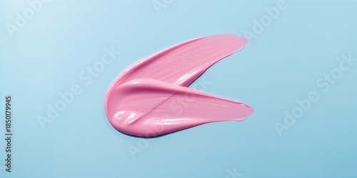 Pair of smooth, shiny cosmetic streaks on a pastel blue surface, suitable for beauty product presentation or branding