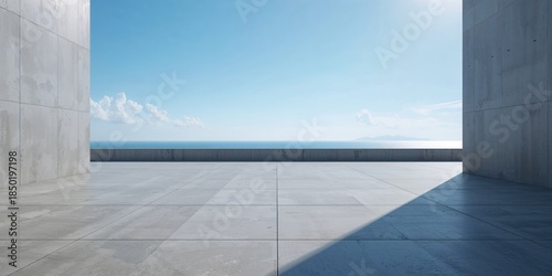 Gray wall and empty concrete floor at seaside plaza with open sky, ideal for editorial header background