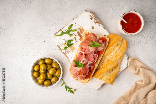 Slika na platnu Baguette sandwich with prosciutto or jamon ham serrano paleta iberica, tomato sa