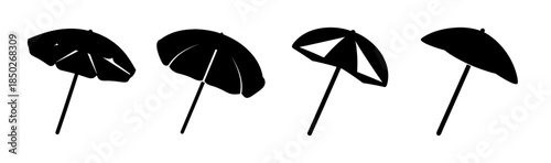 Four black cocktail umbrellas with varying designs placed in a row on a white background scene
