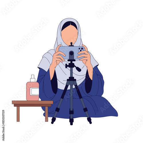 Muslim woman influencer recording video content on a smartphone with tripod and hand sanitizer setup
