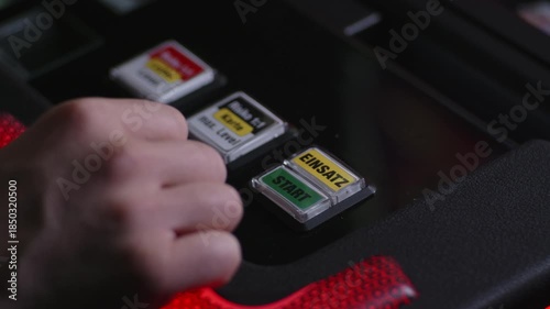 Start button of a slot machine in Germany. Close-up of the gambling machine in a dark casino. Starting the game to win the jackpot. Hand of an anonymous male person.