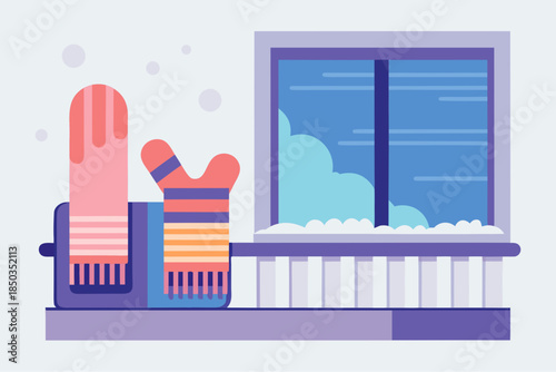 Winter mittens and scarves drying on a radiator by the snowy window with a cold blue sky outside