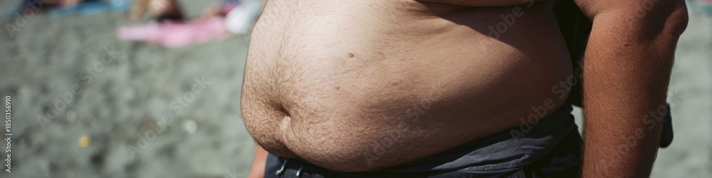 Naklejka premium Close-up of an adult male midsection on a sandy beach