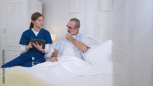 A female nurse assists an elderly patient in bed, conducts a basic health examination, and provides medical information on a digital tablet