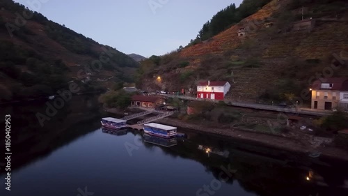 Belesar village with autumn vineyards reflecting in the tranquil miño river