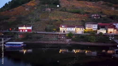 Belesar village with autumn vineyards reflecting in the tranquil miño river