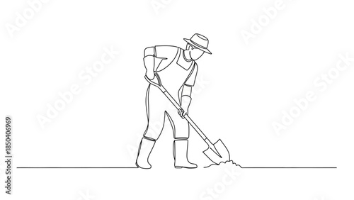 Man in overalls digging with shovel outdoors