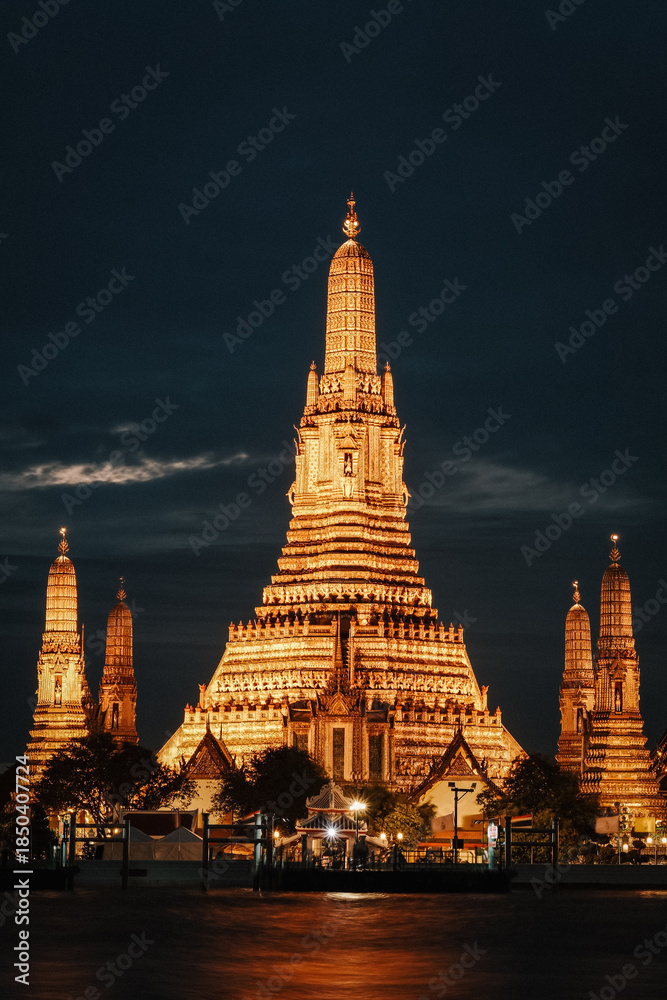 Fototapeta premium Illuminated Wat Arun temple at dusk, a stunning sight in Bangkok, Thailand