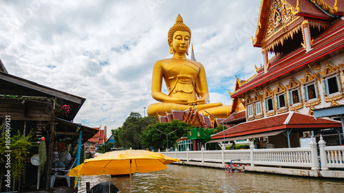 Foto Majestic big buddha at wat paknam phasi charoen under cloudy skies in bangkok