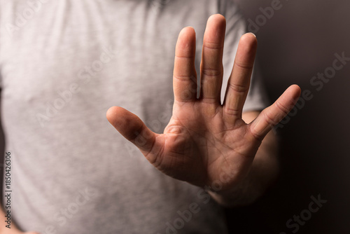 Fotografie Close-up of a hand raised in a stop gesture, conveying denial, disagreement, or