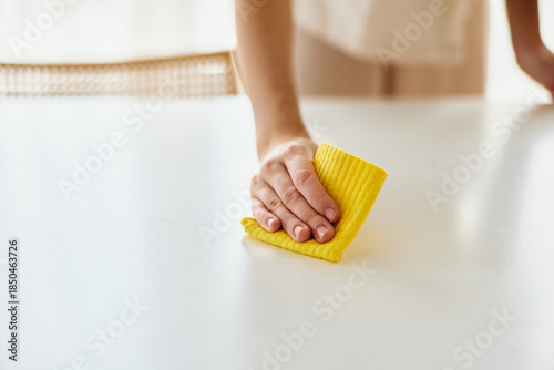 Bild auf Leinwand Cleaning, hand, cloth, table, wipe Closeup of a person wiping a white table with a yellow cloth, domestic surface cleaning for hygiene, household maintenance and gentle wiping motion