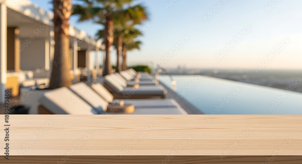 Fototapeta premium Blurred Infinity Pool Scene with Deck Chairs and Palm Trees at Luxury Resort.