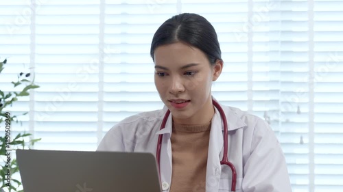 Young women doctor doing her work on computer after finish baby health check.