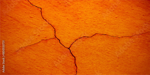 Weathered orange plaster on an old cracked wall reveals a rough grunge texture with aged paint and a dirty concrete surface pattern