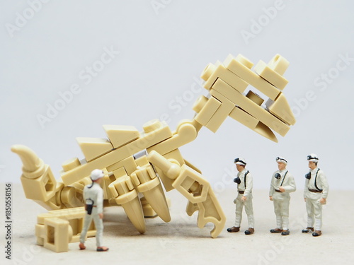Mini toy of action figure and money coin with blur background. Miniature photography concept design. Minifigure of scientist character hold pocket camera with dinosaurs fossil.