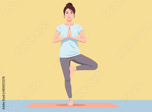 woman in a blue top and grey leggings performs the Tree Pose yoga posture on a mat